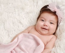 Bebé vestida de rosa sonriendo para la ocasión