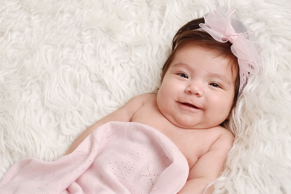 Bebé vestida de rosa sonriendo para la ocasión