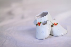 Elegantes merceditas de bebé en color blanco, con velcro y con una flor de color rojo
